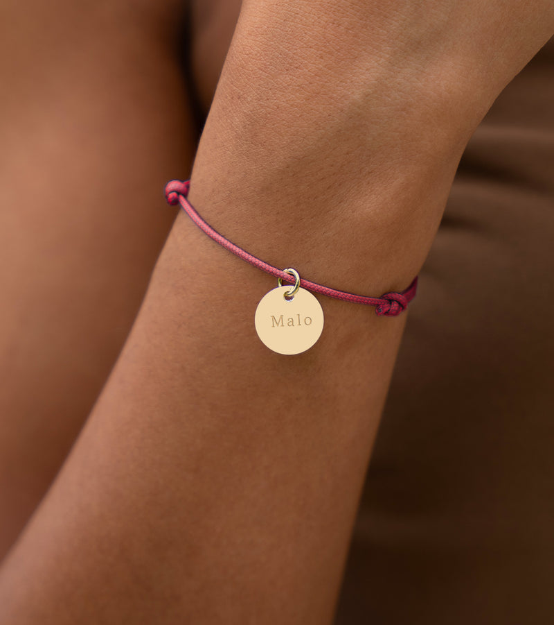 Un bijou raffiné, avec une médaille de 15mm en plaqué or, assorti d'un cordon rose fuchsia.