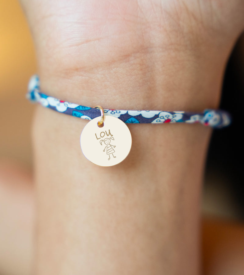 Superbe bracelet agrémenté d'une médaille plaquée or de 15mm, reliée par un lien en Liberty Iris.