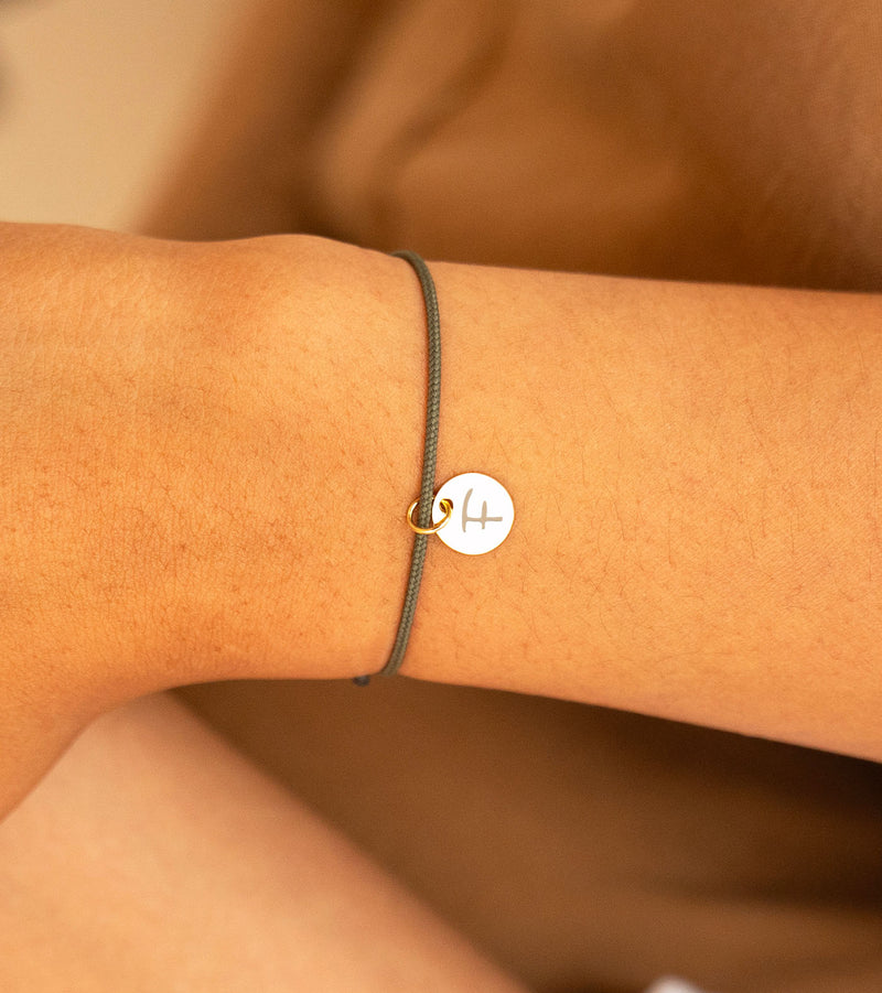 Bracelet personnalisé avec une médaille plaquée or de 10mm sur un cordon kaki, idéal comme cadeau unique.