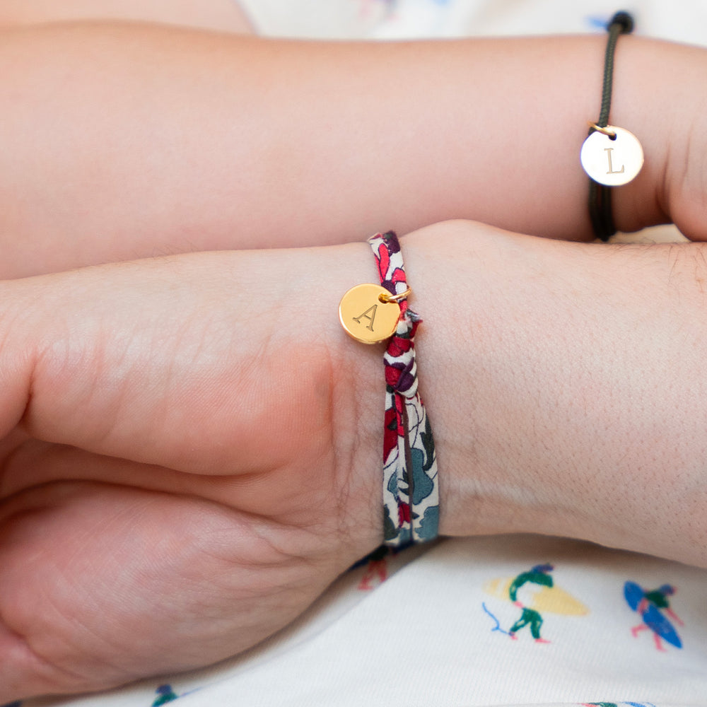 Un bracelet tendance en Liberty Jacinthe, accompagné d'une médaille plaquée or de 10mm, pour une touche de glamour.