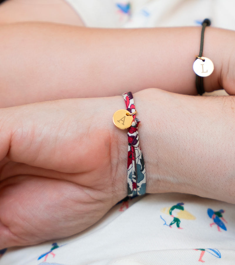 Un bracelet tendance en Liberty Jacinthe, accompagné d'une médaille plaquée or de 10mm, pour une touche de glamour.