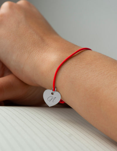 Bracelet argenté en cœur avec cordon rouge pour une touche d'élégance.