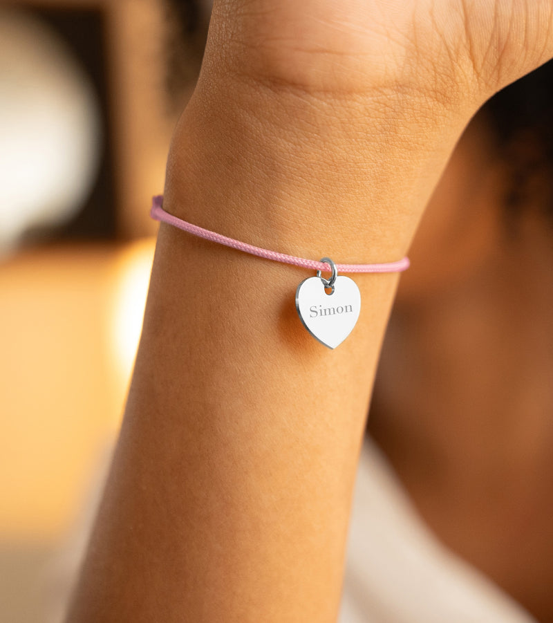 Voici un bracelet en argent, orné d'un cœur de 15mm, avec un cordon rose.