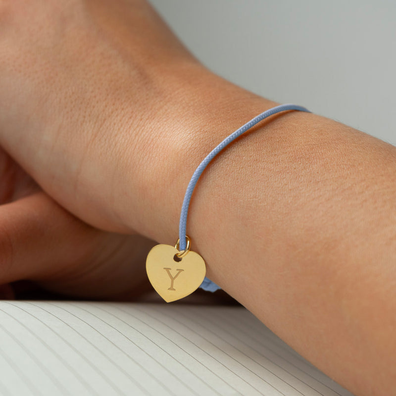 Un bracelet orné d'un cœur plaqué or de 15mm, sur un cordon bleu pastel.