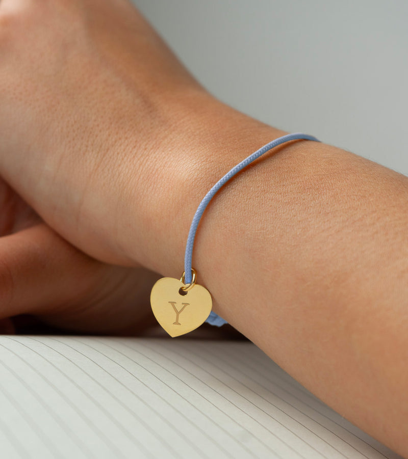 Un bracelet orné d'un cœur plaqué or de 15mm, sur un cordon bleu pastel.