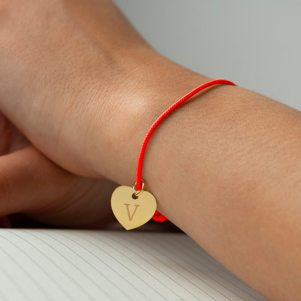Un bracelet orné d'un cœur en plaqué or de 15mm, sublimé par un cordon orange fluo vibrant.