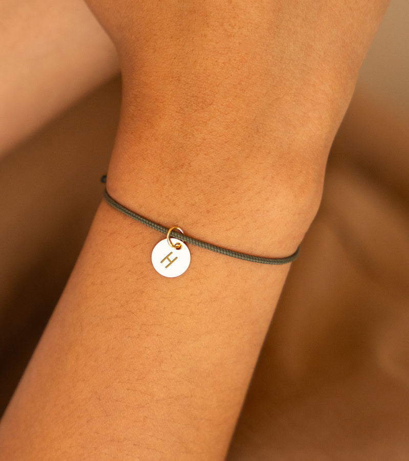 Médaille plaquée or de 10mm sur un bracelet en cordon kaki, gravée selon vos souhaits.