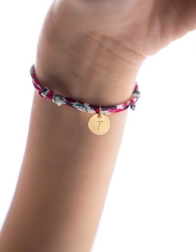 Un bracelet en Liberty Jacinthe avec une médaille plaquée or de 10mm, pour une touche de chic et d'élégance.