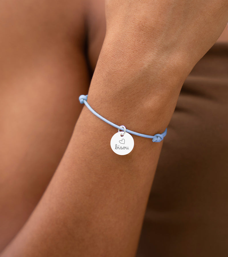 Bracelet personnalisé en argent avec médaille de 15mm sur cordon bleu pastel. Accessoire chic pour exprimer votre style unique.