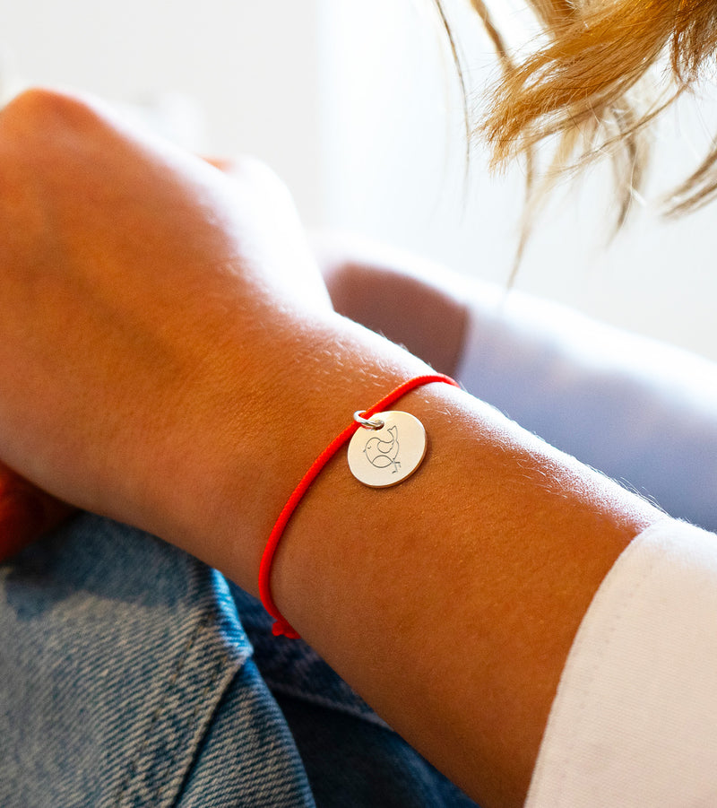Médaille de 15mm en argent sur cordon orange fluo. L'accessoire parfait pour une tenue estivale éclatante !