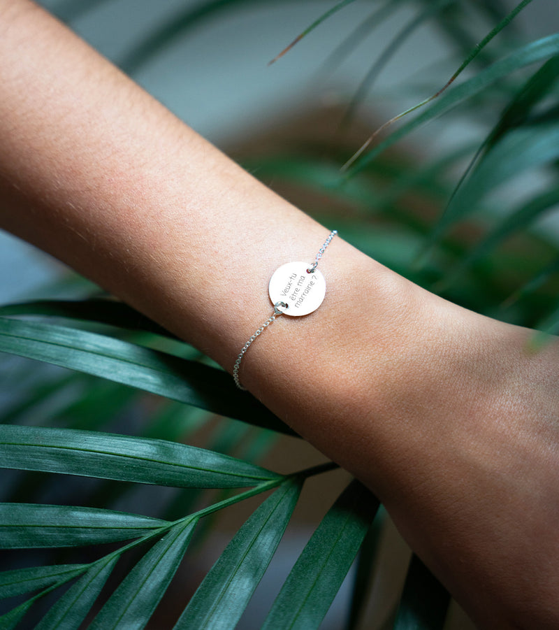 Un bracelet argenté à maille fine, orné d'une médaille personnalisée de 15mm accompagné de deux trous.