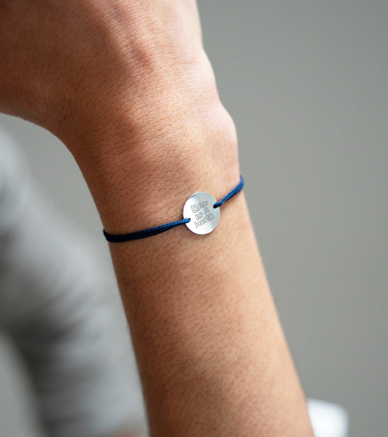 La finesse de l'argent avec une médaille personnalisée de 15mm, sur un bracelet agrémenté d'un cordon bleu marine.