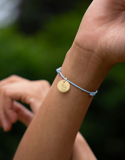 Distinguez-vous avec ce bracelet en cordon bleu pastel, agrémenté d'une médaille plaquée or de 15mm, pour une allure chic et tendance.