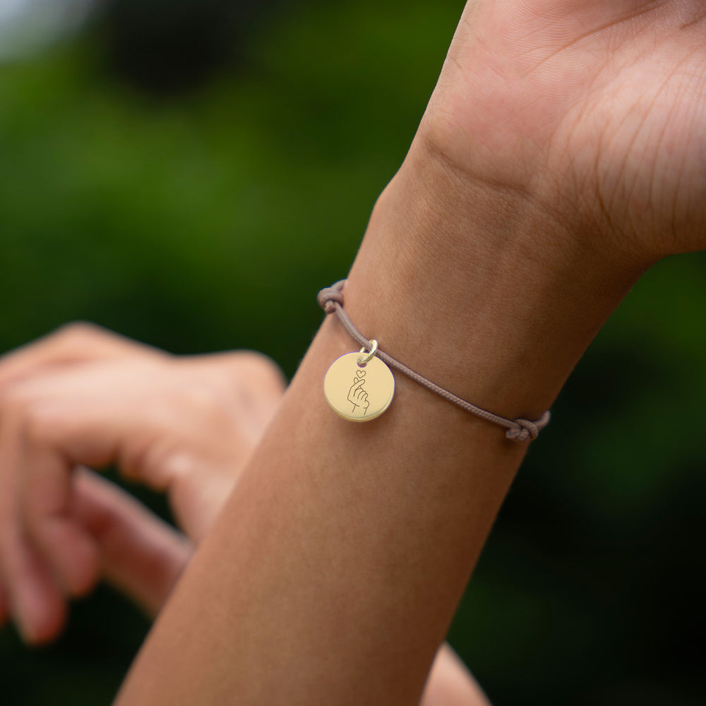 Bracelet personnalisé en plaqué or avec médaille de 15mm sur cordon marron clair.