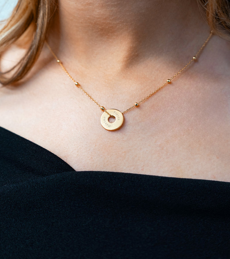 Un pendentif personnalisé, en forme de cible, de 15mm en plaqué or, évoque l'élégance.