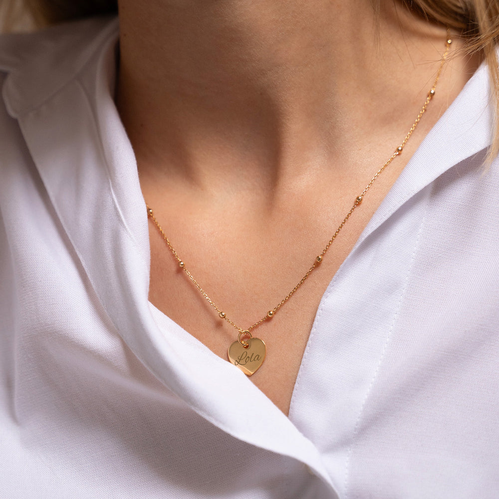 Un pendentif en forme de cœur, plaqué en or, d'une taille de 15 mm. 