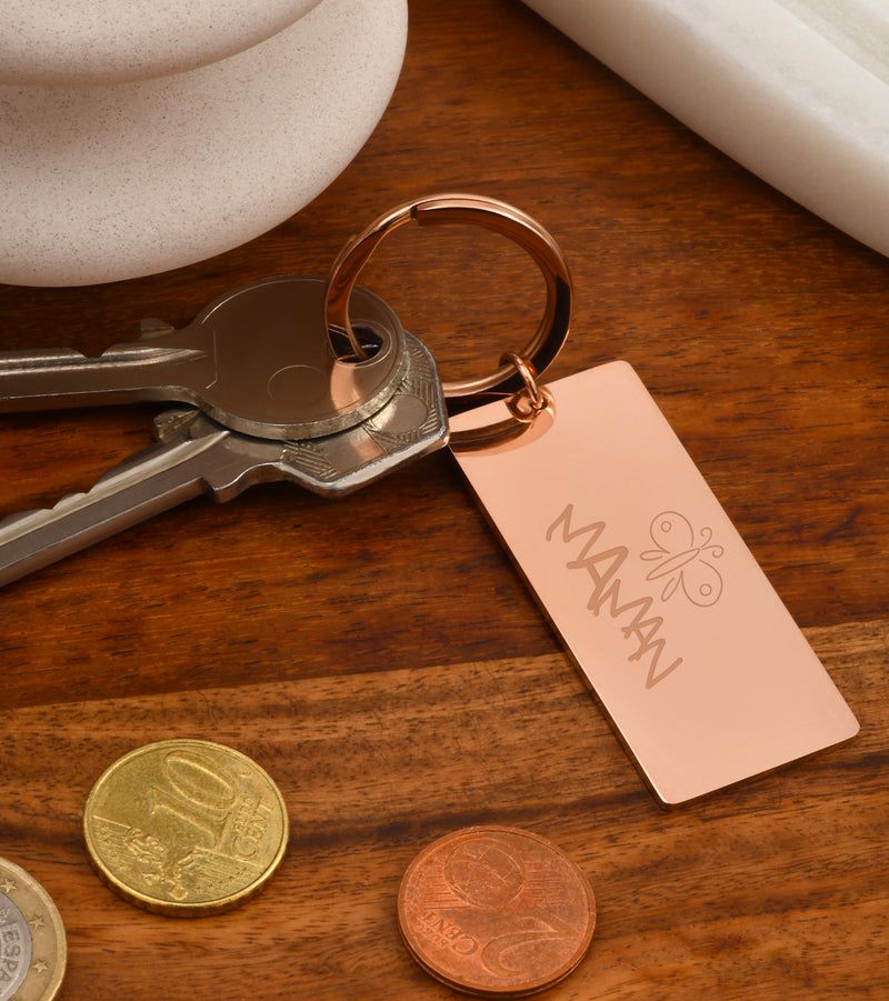 Porte-clé de forme plaque en acier inoxydable doré rose, 50 mm x 22 mm, accompagné d’un anneau rond.